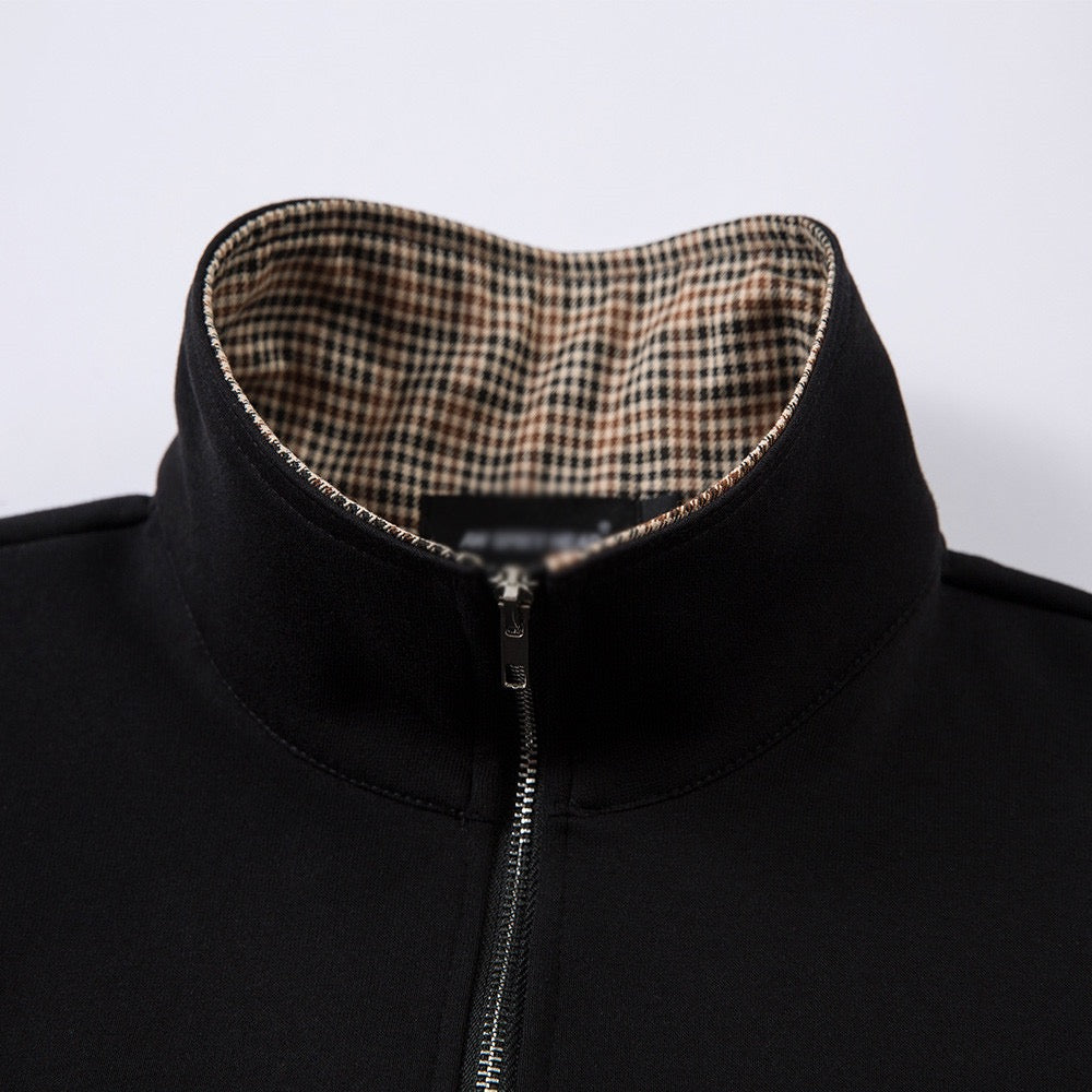 Short-sleeved black half-zip polo shirt with check-patterned collar.