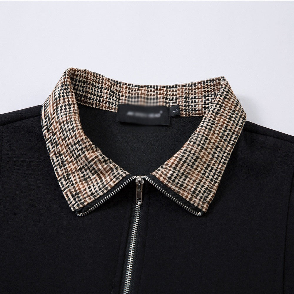Short-sleeved black half-zip polo shirt with check-patterned collar.